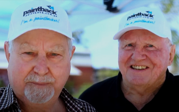 Two elderly men with paintback caps looking at camera