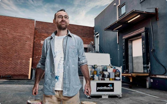 Man looking at sky with background of paintbuckets